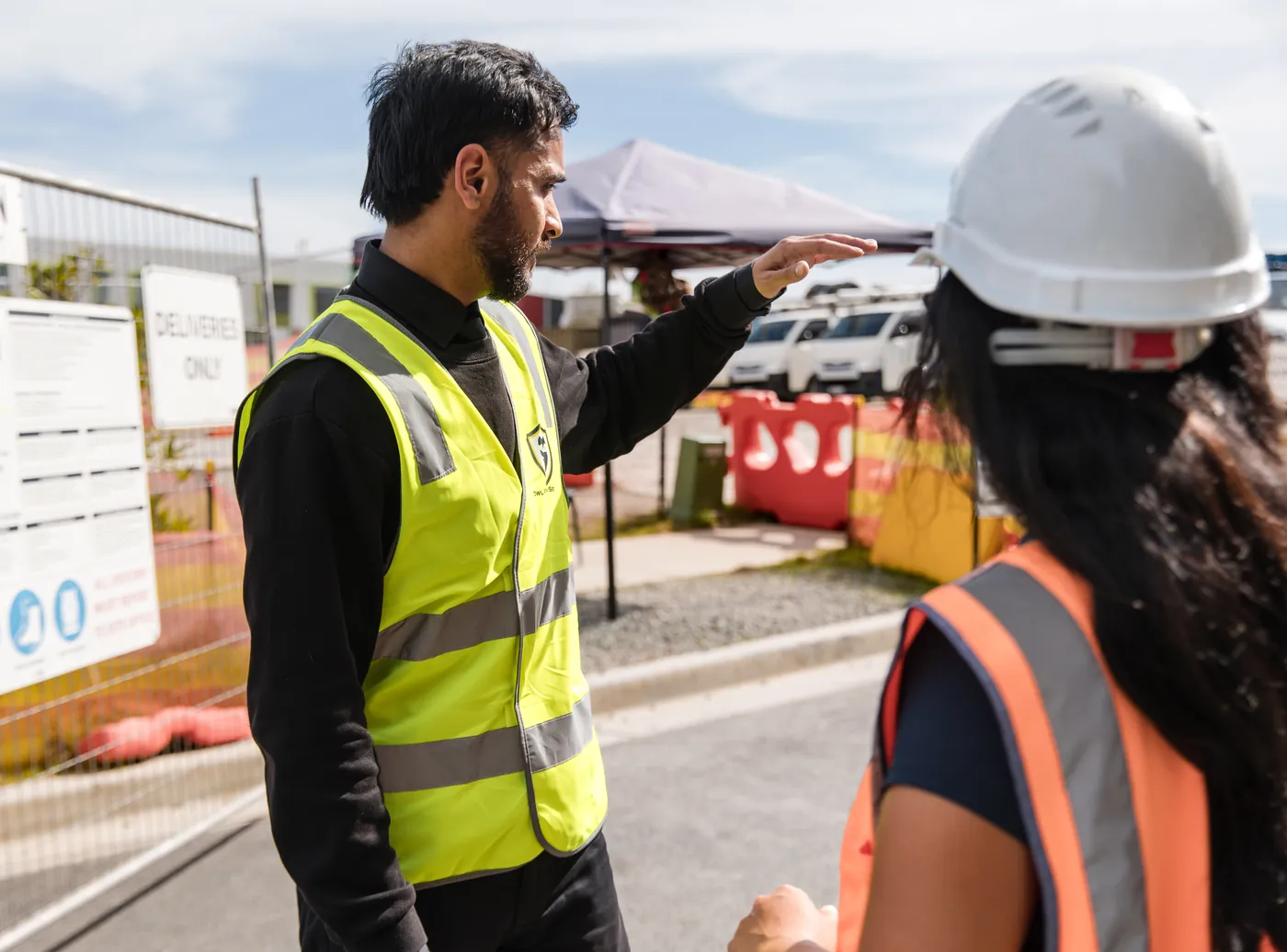 Owl Watch officer directing a site worker at a deliveries only entry